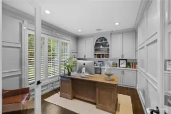 Lower level office with French doors facing entry and side windows facing front of home is filled with natural light. The perfect remote professional workspace. With custom features surrounding you, you may never want to work at the office again.