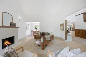 Just inside the entry, the inviting family room is filled with natural light and enhanced by soaring vaulted ceilings. A cozy gas fireplace anchors the space, while the open layout flows seamlessly into the dining area—ideal for everyday living and entertaining.