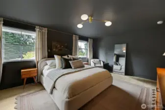 Large windows frame peaceful views of the private, lush backyard—bringing in natural light and a sense of calm to this serene retreat.