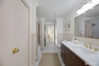 The opposite side of the bath provides a second access point to the “west wing,” offering flexible living options. With its generous size, the bathroom could be easily reconfigured into two separate baths—ideal for creating a dedicated bath for the additional living space.