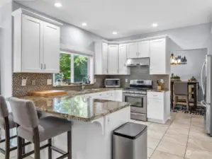 Check out this great kitchen! Trending white cabinetry and slab granite counters with full tile backsplash. Great work triangle and views to the resort-like rear yard