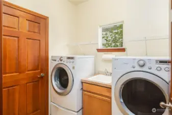 Laundry room with utility sink and cabinet! The washer and dryer stay with the house.