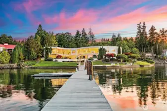 A grand arrival by water – from your private deepwater dock, the S House glows against a painted sky. Two stories of glass capture sunset reflections, while 335’ of manicured shoreline creates a showpiece setting unlike anything else on Wollochet Bay.