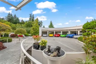 An arrival worthy of a supercar — the sweeping circular motor court leads to a 6-bay luxury garage, where prized automobiles rest in architectural harmony with the home’s iconic curves
