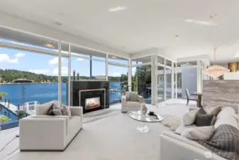Framed by two stories of floor-to-ceiling glass, the living room is a front-row seat to Wollochet Bay’s ever-changing beauty. Crisp modern lines, mirrored accents, and a striking black granite fireplace with jeweled inlay create an atmosphere that is both glamorous and inviting.