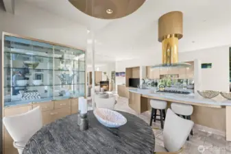 ChatGPT said:  Elegant kitchen dining nook framed by a display cabinet and open sightlines to the living areas. Ideal for casual meals, morning coffee, or entertaining against a backdrop of sophisticated design and waterfront light.