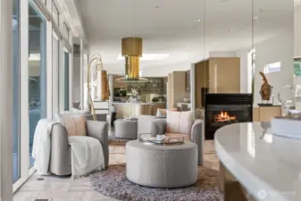 Cozy family room, TV nook off the kitchen with a modern fireplace, mirrored wall, and water views—an inviting spot to relax or entertain in style.