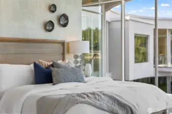 serene tones create a peaceful retreat in the primary suite, framed by architectural windows that capture the home’s modern elegance.