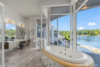 One of a kind primary bath pairs panoramic views with luxurious gold and marble finishes including a jetted soaking tub framed in gold tile.