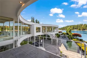 This large private stamped concrete deck off the primary suite gives you the bird's eye view of the stunning architecture surrounding the courtyard, infinity pool, and 180 degree views of Wollochet Bay.