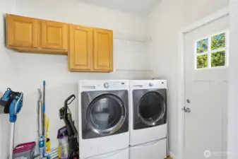 Laundry area with washer, dryer, and built-in storage.