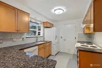 Recently updated kitchen including granite countertops, beautiful tile backsplash, quality cabinetry, and garden window