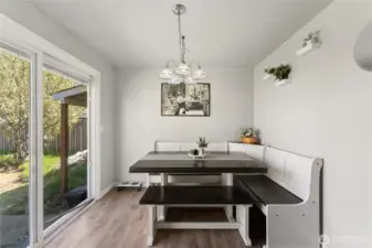 Cozy dining nook with built-in bench seating and backyard views.