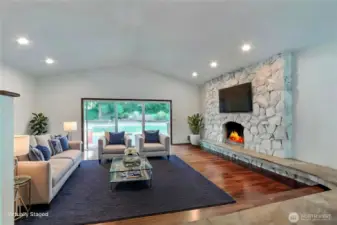 Beautiful walnut floors in spacious living room with fireplace, cathedral ceilings and views to the private outdoors.