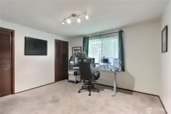 Large bedroom or den with two closets and views to the outside.