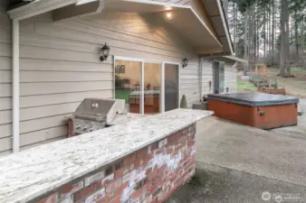 The outdoor space includes a multitude of features, including a barbecue kitchen area.