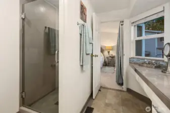 The ensuite bath showcases a sleek walk-in shower with glass enclosure and contemporary tile surround, offering both style and function. Heated tile floors add year-round comfort, while the large vanity and window bring in soft natural light for a spa-like atmosphere. A serene and beautifully finished space that perfectly complements the private primary suite. ????
