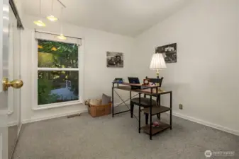 One of 3 additional bedrooms besides the primary suite, this is being used as an office. A large picture window frames peaceful, tree-filled views, bringing in abundant natural light throughout the day. Fresh, neutral tones and plush carpet create a comfortable and inspiring setting for work or relaxation. ????