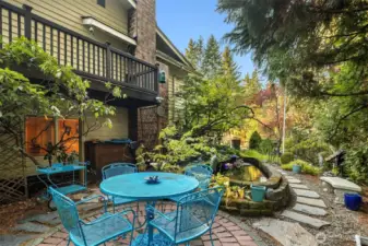 Charming brick patio tucked beside the pond—an inviting spot to dine al fresco or enjoy the sights and sounds of the garden and the trees on your property.