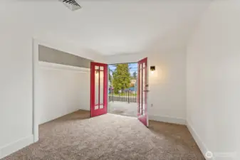 Main house first upstairs bedroom with open doors to balcony