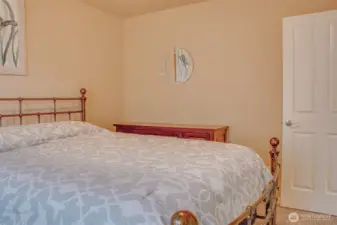 SECOND BEDROOM (from East Wall): Carpeted; Comfortably Fits Queen-Size Bed and Furniture; Bedroom Door Visible on Right Side of Frame