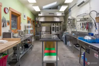 Licensed food establishment kitchen, commercial grade cook area hood and air return with extinguisher system in background