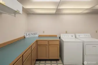 Huge laundry room is complete with folding counter and loads of storage space.