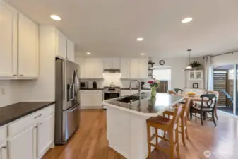 Generous kitchen with stainless appliances, prep island and access to backyard