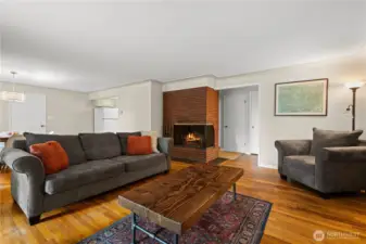 Living room leading to dinning space with wood fireplace
