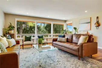 This formal living room with hardwood floors, a gas fireplace, built-ins, and views into the trees is the sellers' favorite spot in the house.