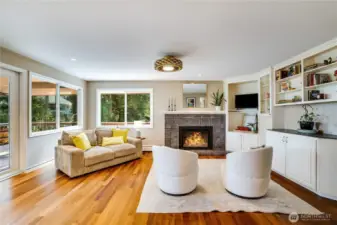 Light the gas fireplace, tuck favorite books and mementos into the built-ins, and open the French doors to the wraparound deck from this cozy family room neighboring the kitchen.