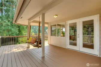 A porch swing waits just outside the French doors, inviting you out to the wraparound, back deck with plenty of space for a grill, and an outdoor lounge area.