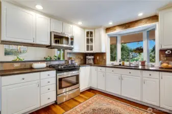 Bar counters at each end of the kitchen give the room its own sense of space while connecting it to the dining room and family room. A tile backsplash compliments the quartz counters and the undermount sink makes for easy clean-up.