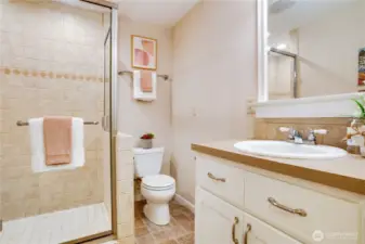 The 3/4 bathroom with a tiled shower and built-ins for linen storage completes the downstairs living space.