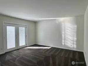 Primary bedroom with beautiful double doors leading to the outside.