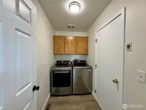 Separate utility room with storage cabinets.