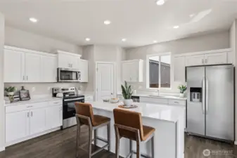 Beautifully open kitchen with stainless steel appliances and large island with breakfast bar. Actual home is under construction and finishes may vary. See site agent for details.