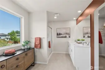 Primary bathroom with step in shower and double vanity with quartz countertops. Actual home is under construction and finishes may vary. See site agent for details.