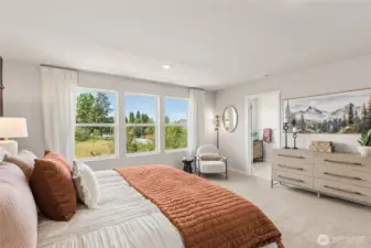 Primary bedroom suite can easily accommodate a King size mattress and more, with the convenience of a connected primary bathroom and walk-in closet. Actual home is under construction and finishes, colors, and materials may vary. See site agent for details.