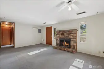 Wood burning fireplace in the living room with lots of natural light surrounding