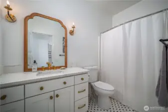 It features penny tile floors, quartz counters, and bronze finishes.
