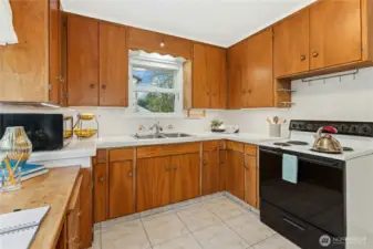 Kitchen features ample natural light and cabinet space.