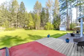 The deck off the primary bedroom has  stairs leading to the patio and the expansive lawn.
