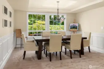 The dining room looks over the back yard space and features a coffered ceiling and classic Wainscotting accent walls.