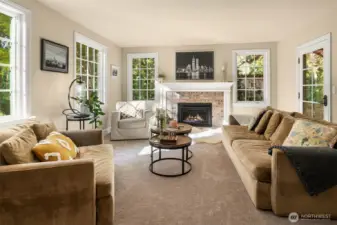 A light filled, warm, relaxing, private home.  A traditional floorplan with large rooms featuring a living room, family room, dining room and eating nook. Here is the inviting and warm living room framed by one of two fireplaces with a custom mantel and displays the details of new wood trim you see throughout the home.