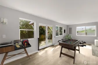 Updated sunroom with stylish flooring and backyard access. This image is virtually staged.