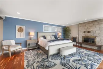 The primary bedroom is a luxurious sanctuary that blends rustic elegance with breathtaking natural beauty. At its heart is a stone fireplace, rising from floor to ceiling in warm, earthy tones-creating a cozy focal point and adding timeless character to this amazing space.
