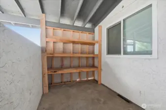 Patio off back with storage shelves.