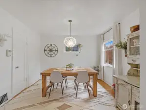 The dining area features space for a large table beneath a striking chandelier