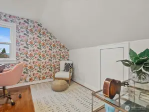 A charming sloped ceiling with floral wallpaper, adding a touch of whimsy